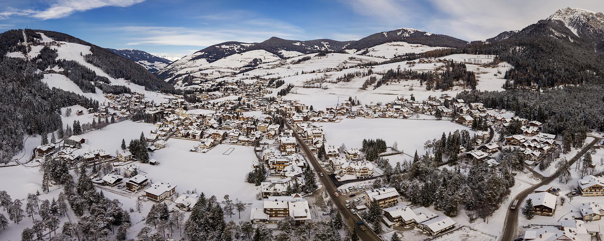 Das schneebedeckte Dorf St. Vigil in Enneberg im Winter von oben fotografiert
