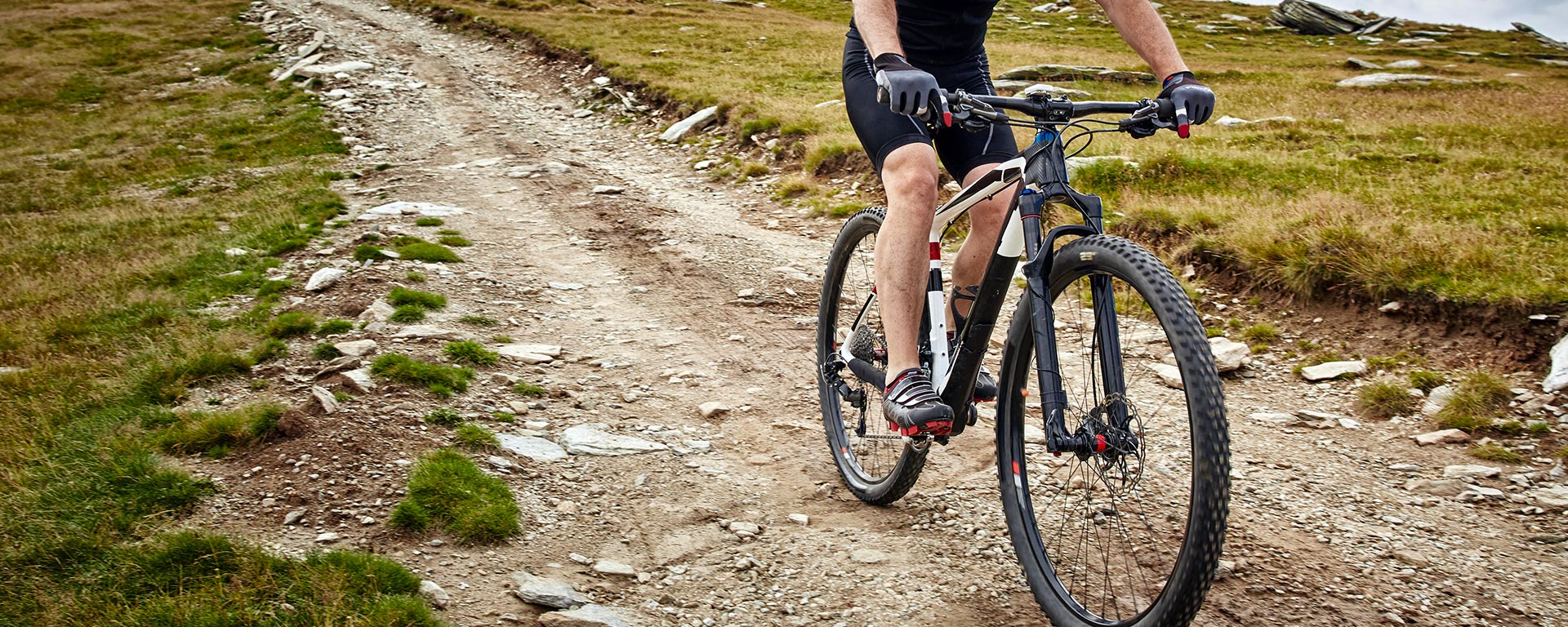 Un ciclista pedala con la sua mountain bike lungo un sentiero sterrato a San Vigilio di Marebbe