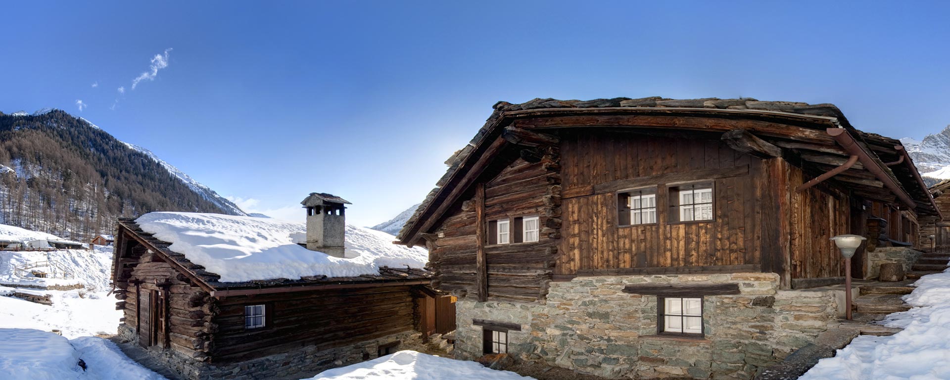 two snow covered mountain huts in the Dolomites near San Vigilio di Marebbe during a sunny winter day