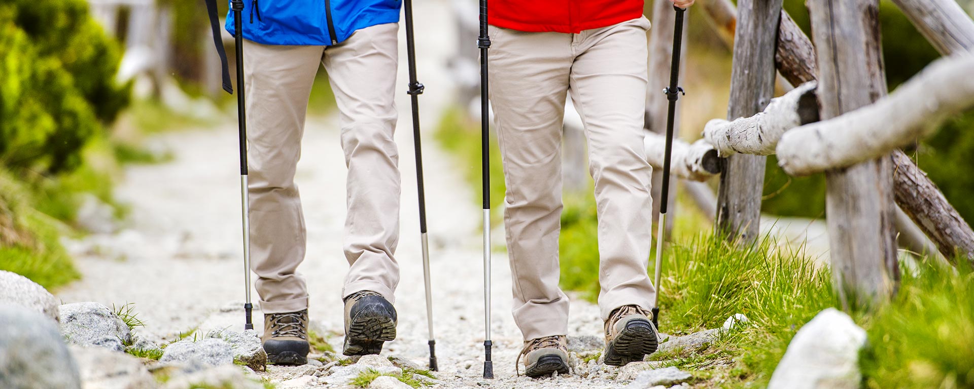 Paar mit Nordic Walking Stöcken und Bergkleidung im Wald