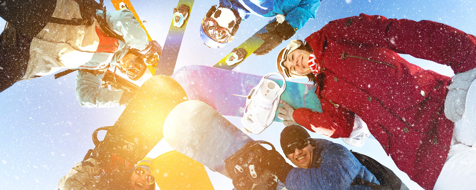 Aufnahme von mehreren Snowboardern mit Sonnenlicht im Hintergrund