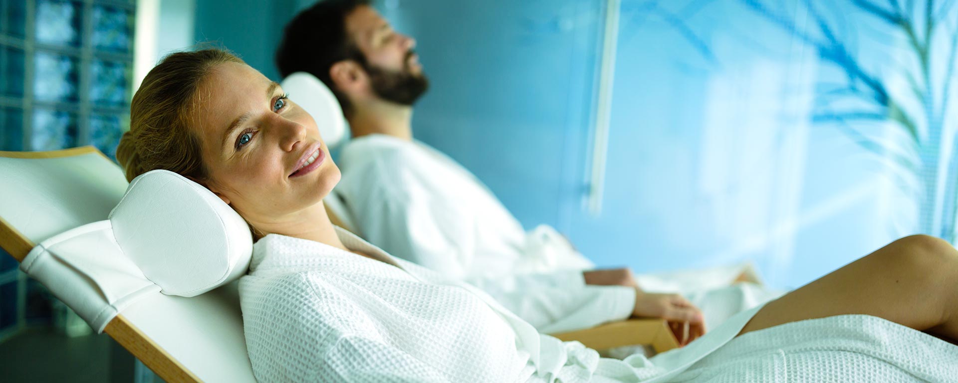 a woman laying on a deck chair in a spa area of a hotel